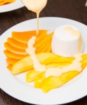 Kokos-Panna Cotta auf Carpaccio von Papaya und Mango mit Zitronengrassauce